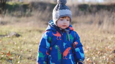 İlkbaharın başında bebekle birlikte parkta yürü. Sağlıklı ve sağlıklı bir bebek ilkbaharda sabun köpüğü patlatır..