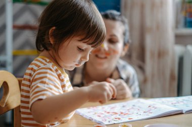 Erken çocuk gelişimi. Çocuğun evde eğitimi. Çocuklara öğretmek için yeni yöntemler ve teknolojiler. Çocukların yaratıcı gelişimi. Çocuk resim yapmayı öğreniyor..