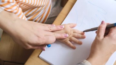 Erken çocuk gelişimi. Çocuğun evde eğitimi. Çocuklara öğretmek için yeni yöntemler ve teknolojiler. Çocukların yaratıcı gelişimi. Çocuk resim yapmayı öğreniyor..