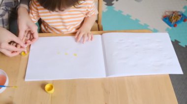 Erken çocuk gelişimi. Çocuğun evde eğitimi. Çocuklara öğretmek için yeni yöntemler ve teknolojiler. Çocukların yaratıcı gelişimi. Çocuk resim yapmayı öğreniyor..