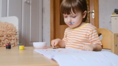 Erken çocuk gelişimi. Çocuğun evde eğitimi. Çocuklara öğretmek için yeni yöntemler ve teknolojiler. Çocukların yaratıcı gelişimi. Çocuk resim yapmayı öğreniyor..