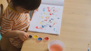 Erken çocuk gelişimi. Çocuğun evde eğitimi. Çocuklara öğretmek için yeni yöntemler ve teknolojiler. Çocukların yaratıcı gelişimi. Çocuk resim yapmayı öğreniyor..