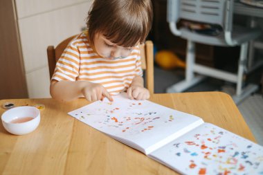 Erken çocuk gelişimi. Çocuğun evde eğitimi. Çocuklara öğretmek için yeni yöntemler ve teknolojiler. Çocukların yaratıcı gelişimi. Çocuk resim yapmayı öğreniyor..