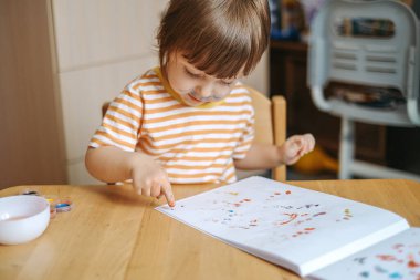 Erken çocuk gelişimi. Çocuğun evde eğitimi. Çocuklara öğretmek için yeni yöntemler ve teknolojiler. Çocukların yaratıcı gelişimi. Çocuk resim yapmayı öğreniyor..