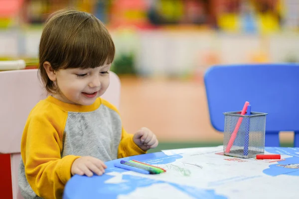 Creative baby development. Baby learns to draw. Early development of children in the Children's Development Center. Happy kid draws.