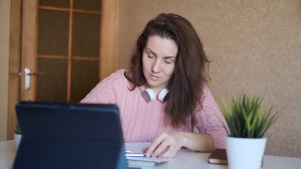 Profesora joven conduce una lección en línea. Entrenamiento en línea. El profesor lleva a cabo la lección a través de Internet. — Vídeos de Stock