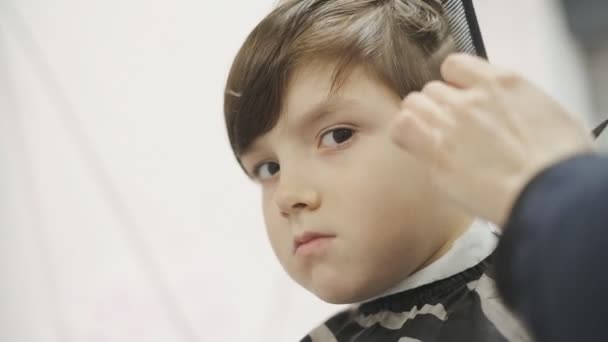 Haarschnitt eines Kindes in einem Friseursalon. Professioneller Haarschnitt für Kinder im Friseursalon. — Stockvideo