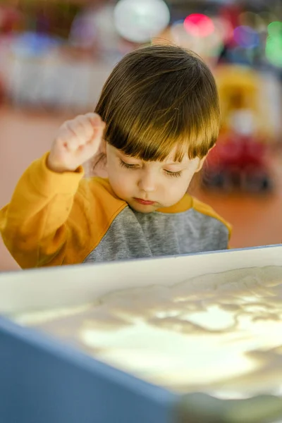 Desarrollo creativo del niño. El bebé dibuja arena sobre vidrio. Desarrollo temprano de los niños. Desarrollo de motilidad superficial y sensaciones táctiles. — Foto de Stock