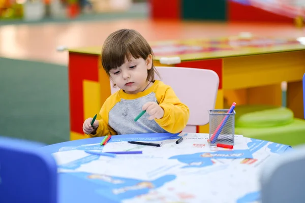 Creative baby development. Baby learns to draw. Early development of children in the Childrens Development Center. Happy kid draws.