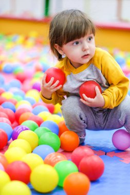 Çocukların yaratıcı gelişimi. Çocuk, çocuk gelişim merkezinde renkli toplarla oynuyor..