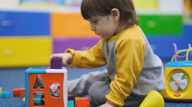 Bebeklerin erken gelişimi. Çocuk merkezinde çocuk gelişimi. Çocuk çocuk odasında oynuyor..