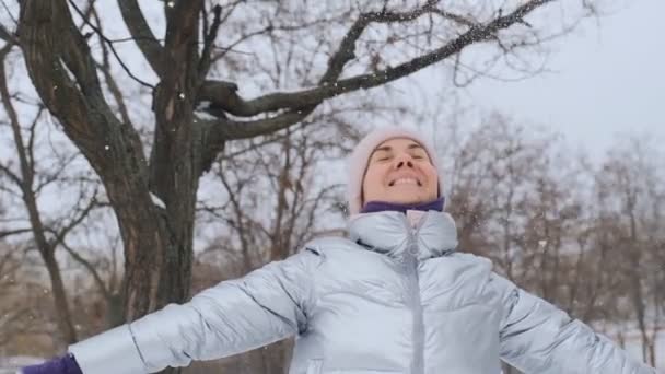 Жінка Стоїть Парку Насолоджується Снігопадами Молода Жінка Радіє Зимовим Снігопадом — стокове відео