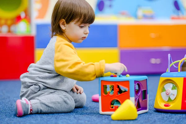 Early baby development. Little boy plays in the children's room. A child plays at an early childhood development center.