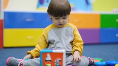 Bebeklerin erken gelişimi. Çocuk merkezinde çocuk gelişimi. Çocuk çocuk odasında oynuyor..
