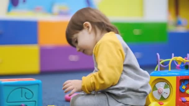 Vroege ontwikkeling van baby 's. Kinderontwikkeling in het kindercentrum. Het kind speelt in de kinderkamer. — Stockvideo