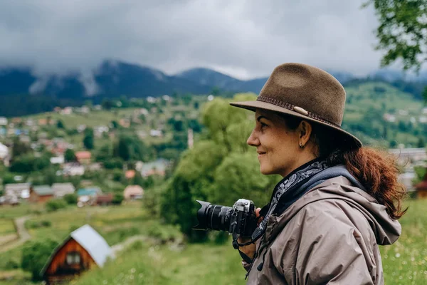 Woman photographer travels in the mountains in summer. Hiking in Europe. A woman photographs alpine landscapes.