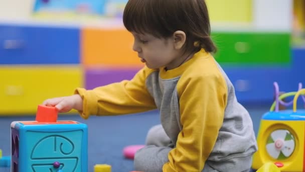 Bebeklerin erken gelişimi. Çocuk merkezindeki çocuk gelişimi. Çocuk, çocuk odasında oynuyor.. — Stok video