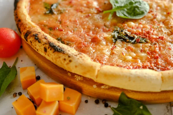 Une pizza fraîche et appétissante est sur la table. Nourriture d'un restaurant italien. Cuisiner une pizza. Ingrédients de pizza. — Photo