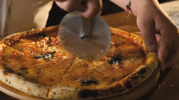 Włoska pizzeria. Szef kuchni kroi gotowaną, apetyczną pizzę. Szybkie i pyszne włoskie jedzenie. — Wideo stockowe