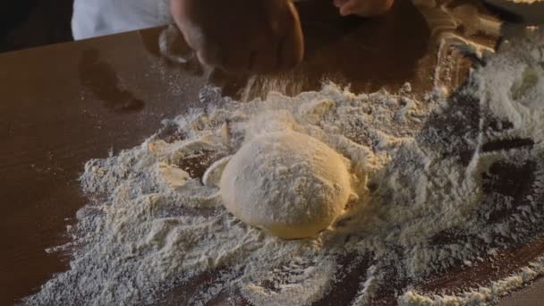 Cuisiner une pizza italienne dans un restaurant. Étendre la pâte à pizza crue avec vos mains. Un chef professionnel étire et tord la pâte à pizza italienne douce avec ses mains. — Video