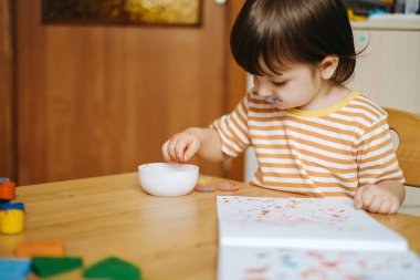 Erken çocuk gelişimi. Çocuğun evde eğitimi. Çocuklara öğretmek için yeni yöntemler ve teknolojiler. Çocukların yaratıcı gelişimi. Çocuk resim yapmayı öğreniyor..