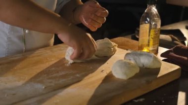 Pizzacıda pizza pişirmek. Şef pizza yapmak için elindeki çiğ hamur toplarını buruşturur. Lezzetli İtalyan yemekleri..