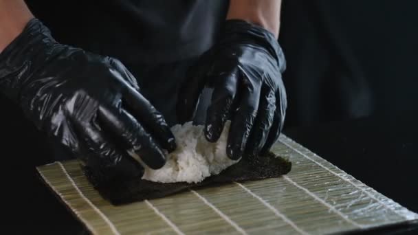 日本料理店でプロの寿司作り 黒手袋の寿司職人は魚介寿司を準備します 日本の伝統料理 — ストック動画