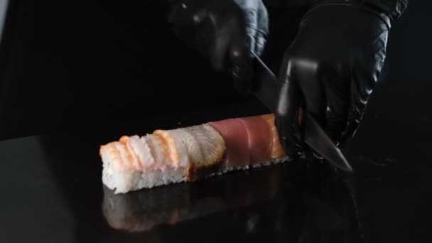 Een Sushi Maker Snijdt Broodjes Een Stenen Bord Kok Zwarte — Stockvideo