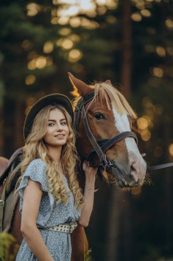 Genç ve güzel bir kadın sonbaharın başlarında atıyla ormanda yürür. Ormanda bir atla yürümek..