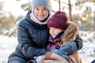 Anne ve kızı Noel tatilinde kış ormanında bir kızakta oturuyorlar. Kış tatilinde çocuklarla aktif kış tatili. Kızımla kış parkında kızak kayarken..