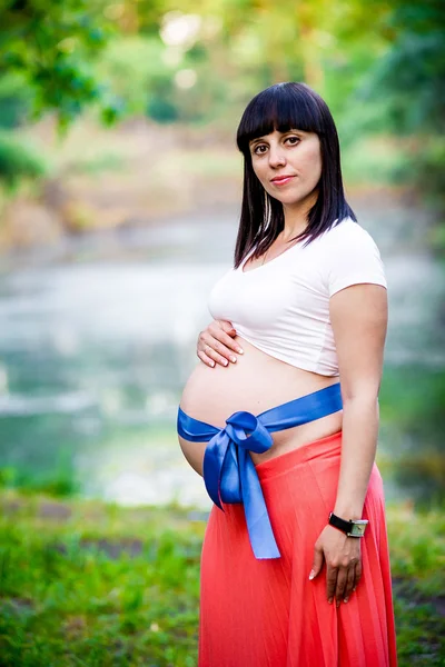 湖の近くの妊娠中の女性. — ストック写真