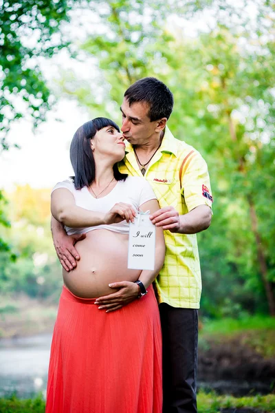 Mulher grávida feliz e seu marido no parque — Fotografia de Stock