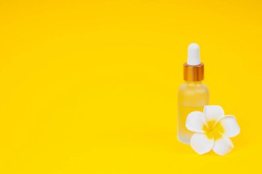 İnternet sitesi kozmetik yağı için sarı arka planda ve metin için yeri olan damlatıcı şişedeki pankart.