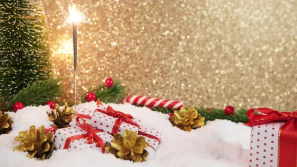 キラキラはギフトでぼやけたクリスマスの背景に照らされました テキストのための場所と黄金のボケ — ストック動画