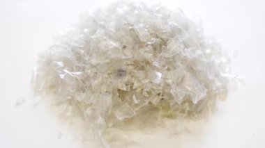 PET şişe gevreği yığını. Ezilmiş plastik şişe. Evcil hayvan. Plastik şişe geri dönüşümü, geri dönüşümlü malzemeler, üretim ve fabrikalar. Çevre kavramını sakla. Geri dönüşüm simgesi, alınıyor, PET simgesi.