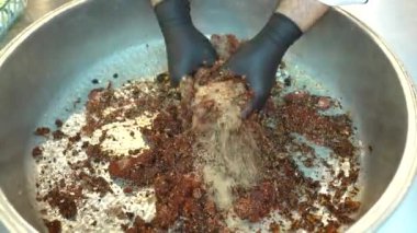 The cook is preparing Cigkofte / Turkish Traditional Food. Preparation for making raw meatballs in a copper pan. Shooting closeup video 