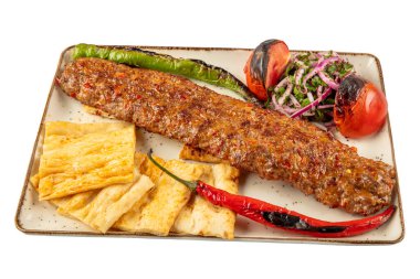 Türk usulü Adana kebabı. Tabakta sebzeli Türk Adana Kebabı.