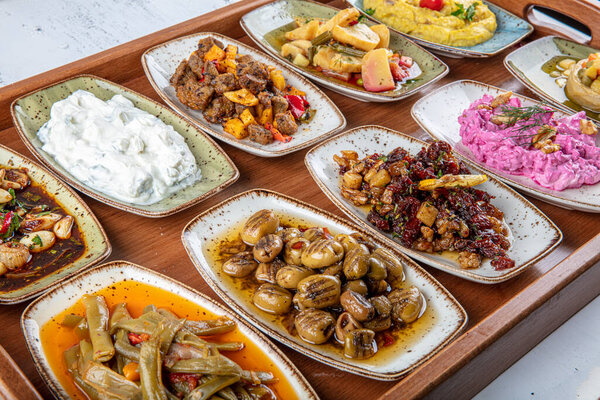 Turkish Cuisine Cold Appetizers (appetizers with olive oil). Turkish Cuisine Cold Appetizers. Turkish appetizers in colorful plates. yogurt and various boiled herbs
