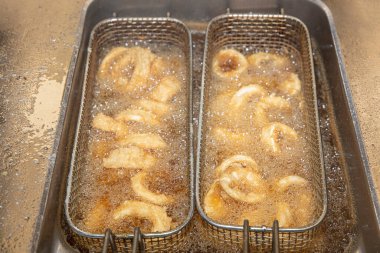 Mürekkep balığı yağda kızarır. Yağda kızartılmış yiyecek. Kızgın yağda kızartılmış Calamari Halkaları.