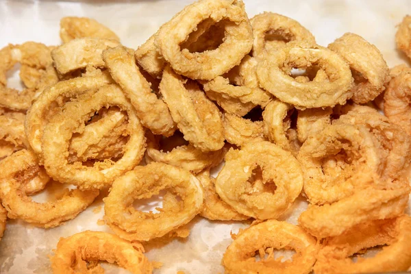 Fried squid rings with salad dressing on white plate at a restaurant. Deep Fried Calamari Rings in boiling oil.