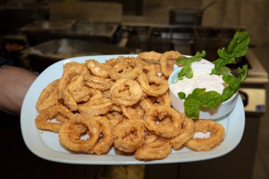 Restoranda salata soslu kızarmış kalamar halkaları. Kızgın yağda kızartılmış Calamari Halkaları.