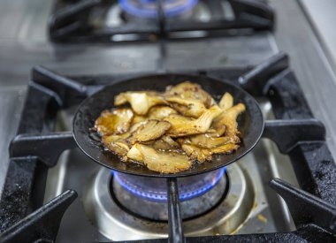 Kızarmış istiridye mantarı. Siyah dökme demir tavada taze bitkilerle kızartılmış mantar. Üst görünüm