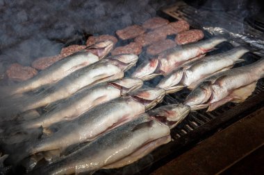 Izgara levrek balığı yakın plan. İşlem halinde. Avrupa levreği, aşçı mutfakta ızgara yapıyor.