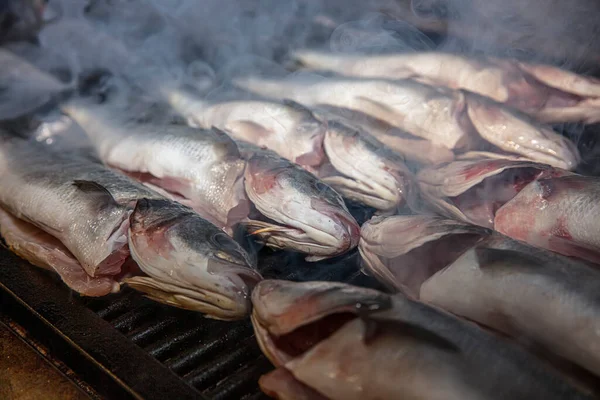 Grilled sea bass fish closeup. In process. European sea-bass, chef is grilling in the kitchen - BBQ — Stock Image Grilled Sea Bass Fish Closeup Process European Sea Bass Chef Stock Photo
