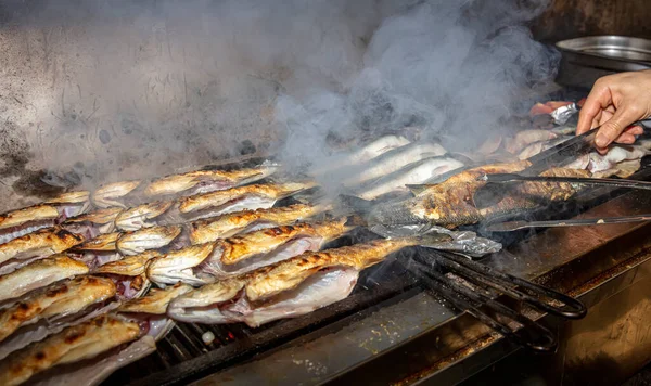 Grilled sea bass fish closeup. In process. European sea-bass, chef is grilling in the kitchen - BBQ — Stock Image Grilled Sea Bass Fish Closeup Process European Sea Bass Chef Stock Picture