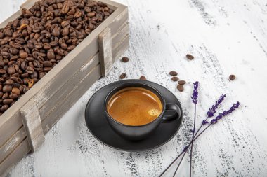 Duble espresso. Eski ahşap masanın üzerinde kahve çekirdeğiyle espresso bardağını kapat..