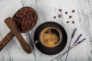 Duble espresso. Eski ahşap masanın üzerinde kahve çekirdeğiyle espresso bardağını kapat..