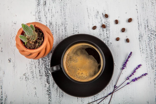 Close-up of espresso coffee in a single shot glass cup with saucer on the  wooden table. Stock Photo