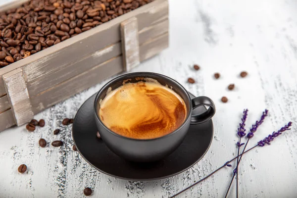 Double espresso. Close up espresso glass cup with coffee bean, on old wooden table.