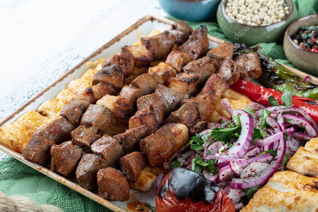 Turkish cuisine delicious ciger skewer. Liver skewer, Turkish Ciger Shish Kebab on small barbecue with tomatoes, delicious, natural, close-up looking.